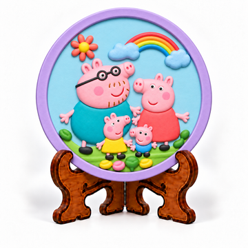 Colourful round DIY pig family craft plaque with rainbow, clouds and flowers displayed on decorative stand