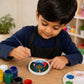 Child painting a colourful moon and lantern DIY craft at a table.