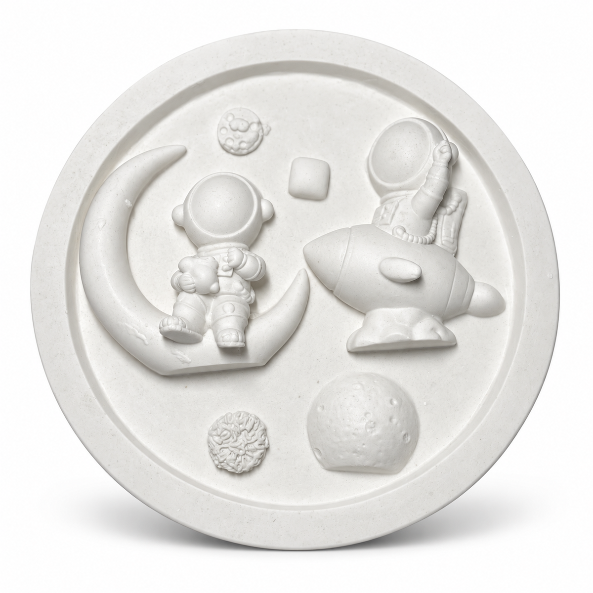 White unpainted round DIY space craft plaque featuring two astronauts, rocket, crescent moon and raised planet designs ready for painting.