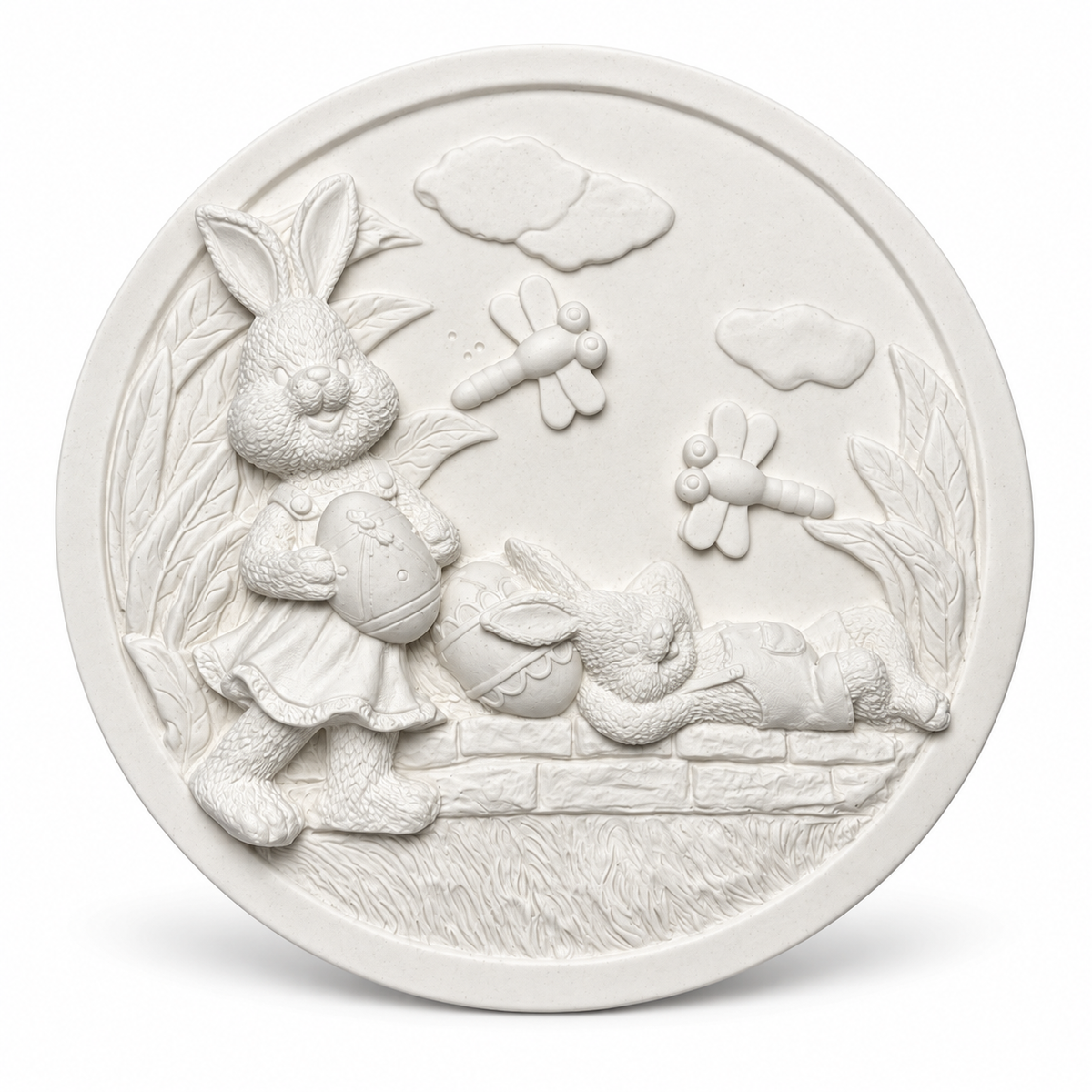 White unpainted circular Easter bunny craft plaque with raised rabbits, Easter eggs, dragonflies and garden details.