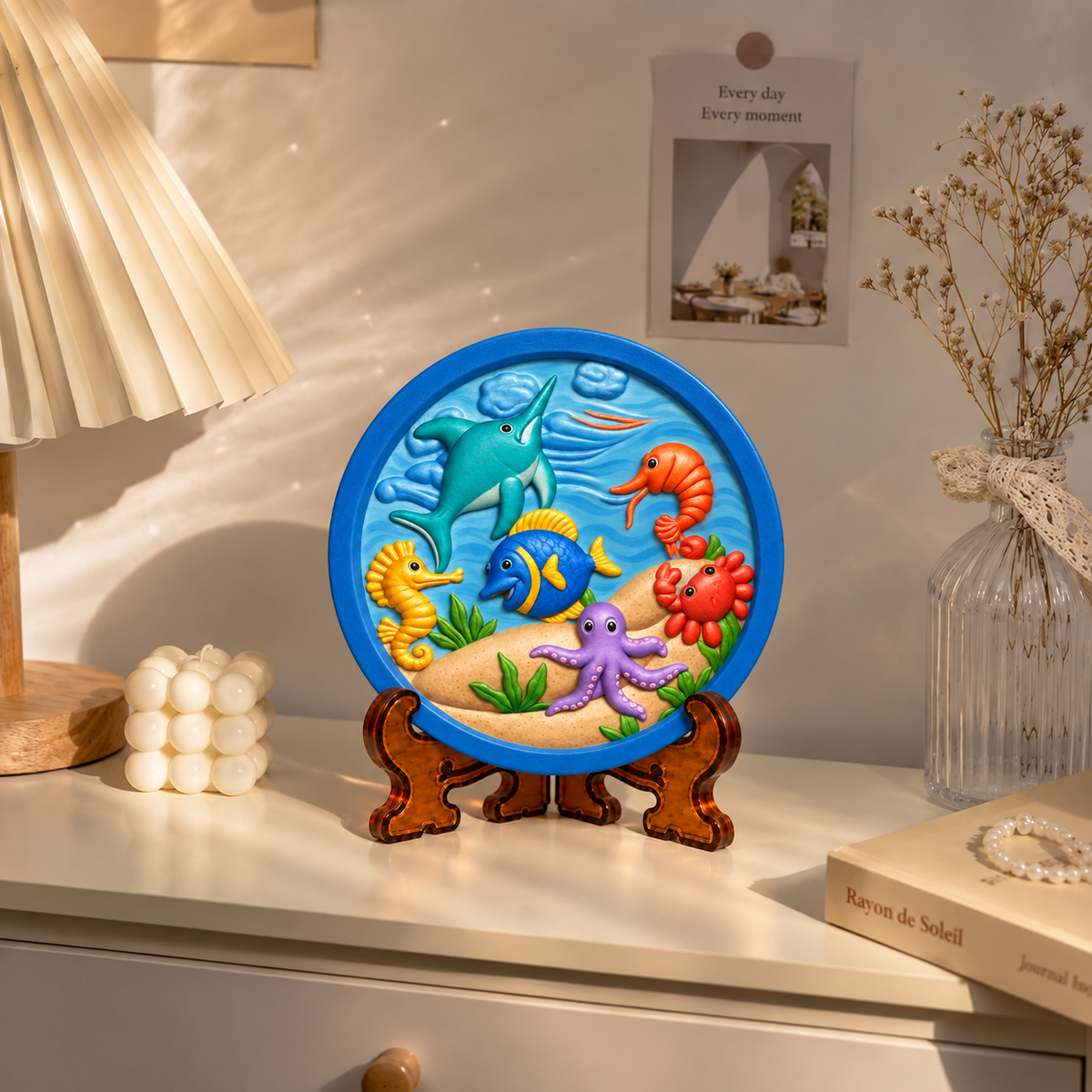 Round DIY ocean painting craft featuring colourful dolphin, fish, seahorse, octopus, crab and underwater scene on a display stand.