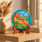 Colourful dinosaur DIY painting craft with raised prehistoric landscape displayed on a decorative stand.