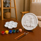 Unpainted Nativity scene DIY craft with paint pots, palette and brushes.