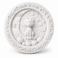 A circular white decorative plaque featuring a carved Halloween scene with a cat sitting on pumpkins under a crescent moon, surrounded by a floral vine border.